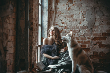 Wooman with dog husky, huskies near old window in collapsed old house  and brick wall. Farytale.