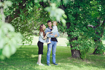 Fototapeta premium Family - mom, dad and daughter in the Park, full length.
