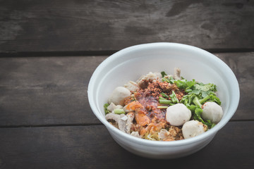 noodles in a styrofoam cup on wood background,selective focus.