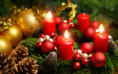 Dritter Advent, Dekoration mit roten Kerzen, Tannenzapfen und goldenen Kugeln