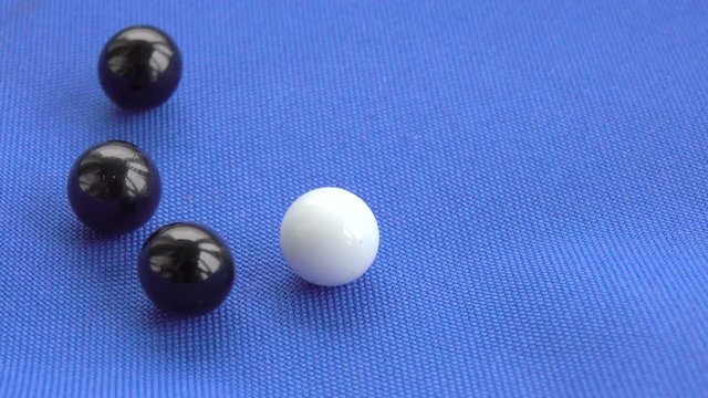 White and black marbles on blue background