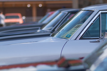 A lot of cars standing in a row. Glass with reflection.