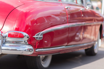 Fototapeta na wymiar Red retro car. The view from the side. Chrome lining. An American classic.