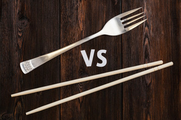 Wooden pairs of chopsticks vs fork. Abstract conceptual image