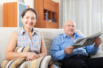Happy couple of grandparents with newspaper