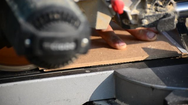 Man sawing MDF board with circular saw