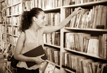 Woman taking literature books in store