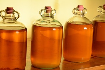Homemade wine in demijohns on a bench