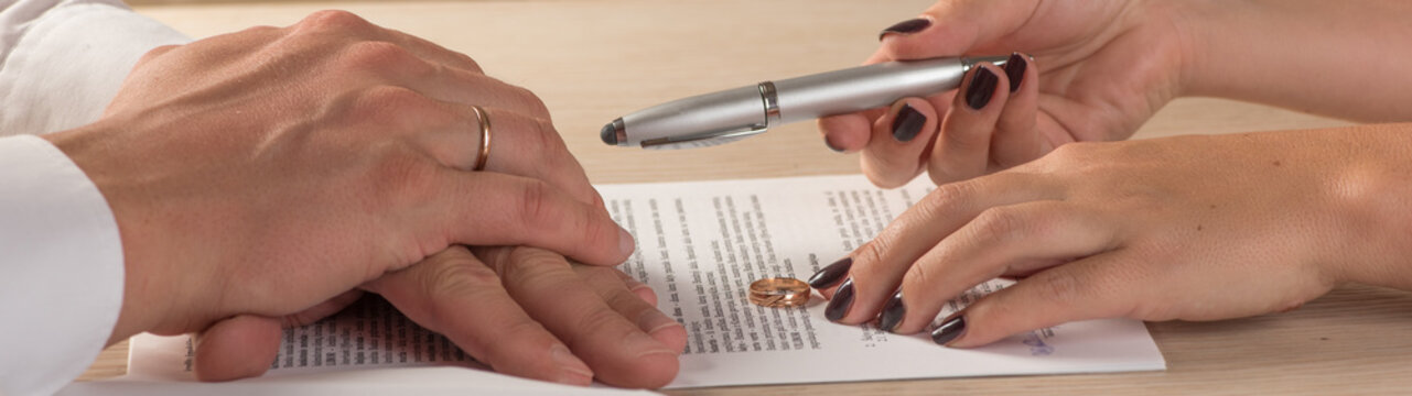 Wife and husband signing divorce documents or premarital agreement