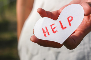 Hand holding the paper writing the word help