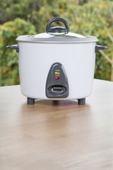 Electric rice cooker on wooden table