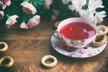 against the background of pink roses and drying tea cup