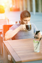 Man with mobile phone drinking beer