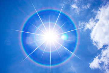 Sun corona on blue sky.