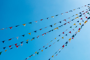 Colorful buddhist prayer flags hanging against blue sky background