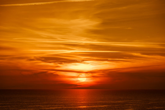 Piękny złocisty zachód słońca z widokiem na ocean © Marek AGInt
