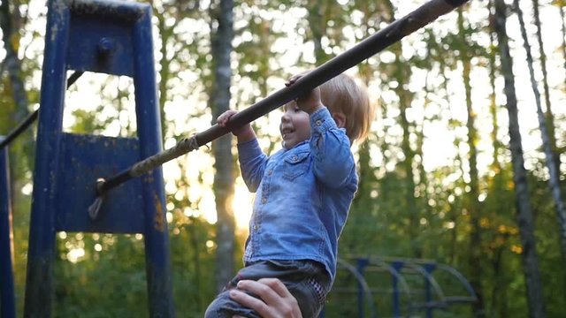 little child practicing on the horizontal bar