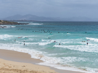 Fototapeta na wymiar Surfer at a popular beach break on Fuerteventura.