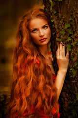 Beautiful girl with red hair in autumn park
