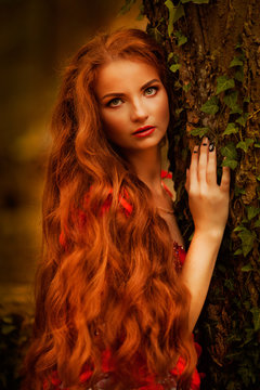 Beautiful Girl With Red Hair In Autumn Park