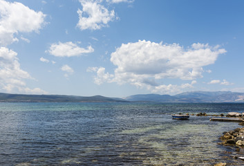Seascape with old wooden pier and a boat