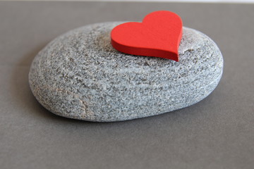 Fototapeta premium Love. Red heart on the stone background. Gray background. Heart heaviness. Heart healthy. 