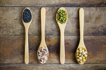 Black sesame,Riceberry Bran, green beans, soybeans in wood spoons on wooden background.