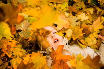 Naklejka na ściany i meble Autumn - child in fallen leaves
