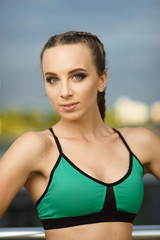 Fototapeta na wymiar Concept: healthy lifestyle, sport. Attractive happy girl fitness trainer do outdoor workout at modern downtown urban area during sunset.