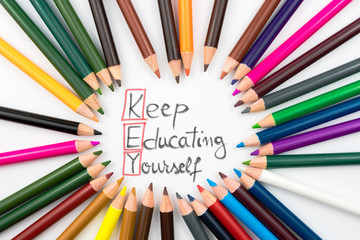 Colouring pencils in circle arrangement with message KEY Keep Educating Yourself