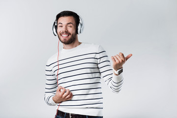 Smiling bearded man using headphones.