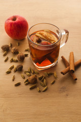 Hot tea with apple, cinnamon and cardamom. Autumn healthy drink to warm yourself in cold weather. Vitamin beverage with spices.