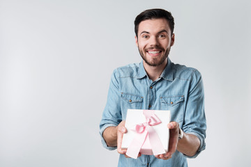 Happy bearded man smiling and holding present box.