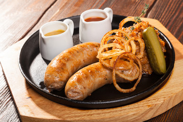 Fried sausages with sauces and potatoes