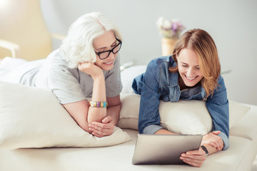 Happy smiling woman and her adult daughter resting at home