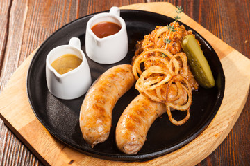 Fried sausages with sauces and potatoes