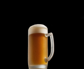 cold beer in a glass on a black background