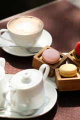 Cup of cappuccino and macaroons