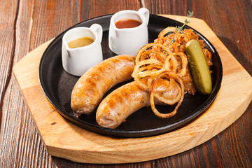 Fried sausages with sauces and potatoes