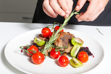 Chef decorating meat dish