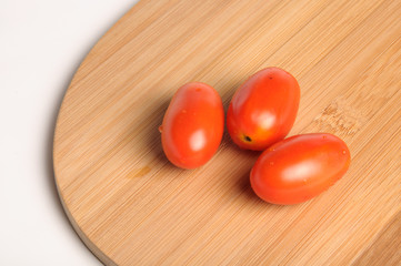 red cherry tomatoes on Bamboo cutting board