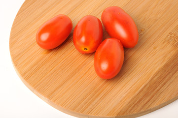 red cherry tomatoes on Bamboo cutting board