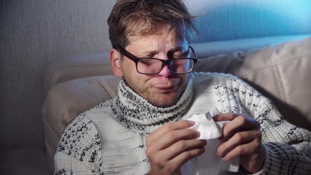 Sick man blowing his nose in the tissue, young ill man in bed

temperature feeling bad infected by winter grippe virus in flu and influenza health care concept
