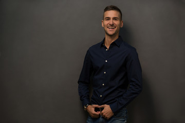 Fototapeta premium Close up picture of happy smiling mans face in studio. Handsome man with short haircut toothy smiling for camera while posing over grey background. Fashion or vogue concept.
