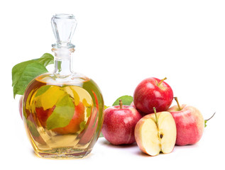 apple cider vinegar in a glass vessel and red apples