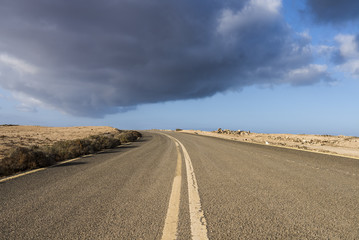 Endless street in the dessert in the last, warm light of the eve