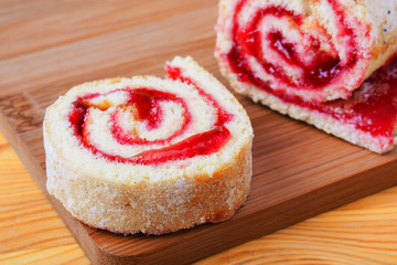 Sweet roll with jam on a cutting board.