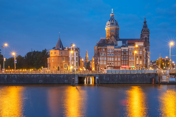 Obraz na płótnie Canvas Night panoramic city view of Amsterdam canal, bridge and Basilica of Saint Nicholas, Holland, Netherlands. Long exposure.
