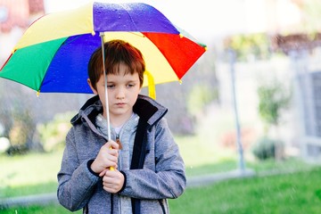 Seven years old boy standing at the rain