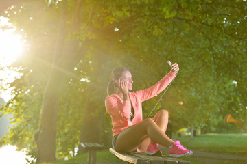 Young woman taking rest after jogging - workout at the park